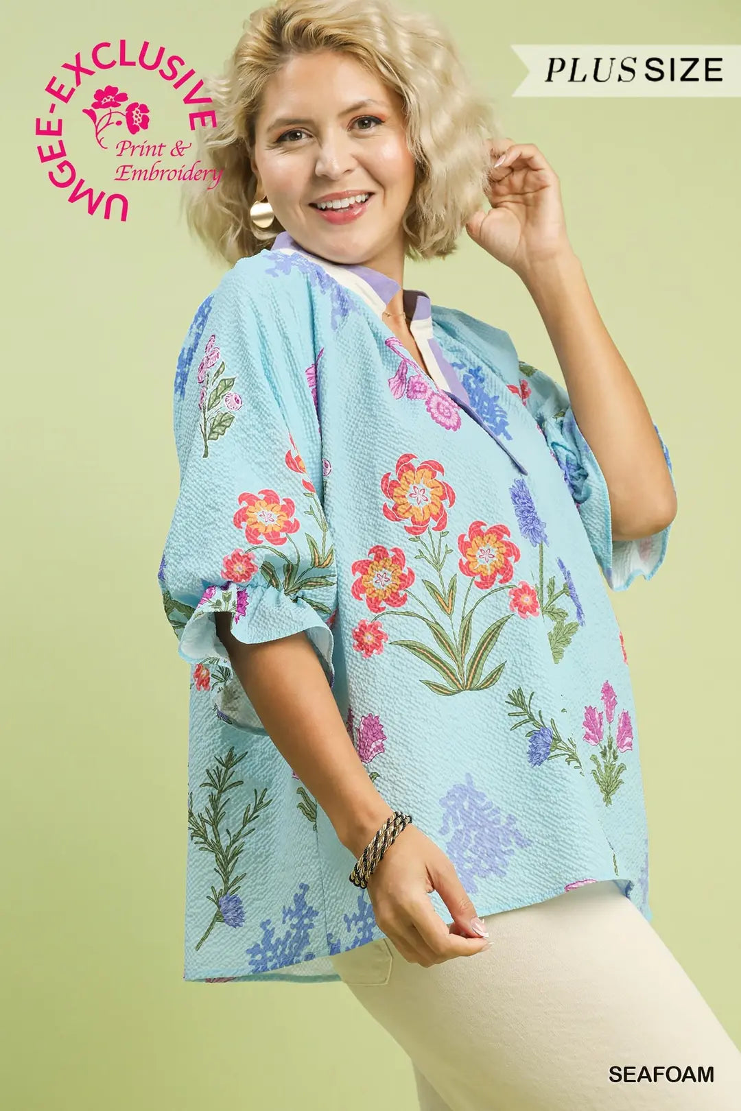 Woman wearing a floral kimono-style top with a green background