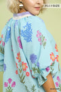 Woman wearing a plus-size floral kimono with a light green background
