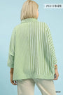 Woman wearing a green and white striped plus-size shirt against a light blue background.