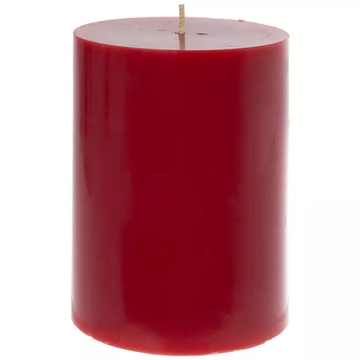 A single red pillar candle with a natural wick, photographed against a solid white background.