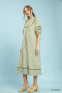 Woman wearing a light olive striped dress on a light blue background