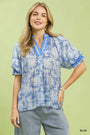 Woman wearing a blue patterned top with a green background