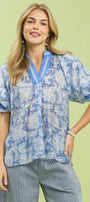 Woman wearing a blue patterned top with a green background