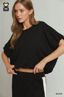 Woman wearing a black outfit with a plain background