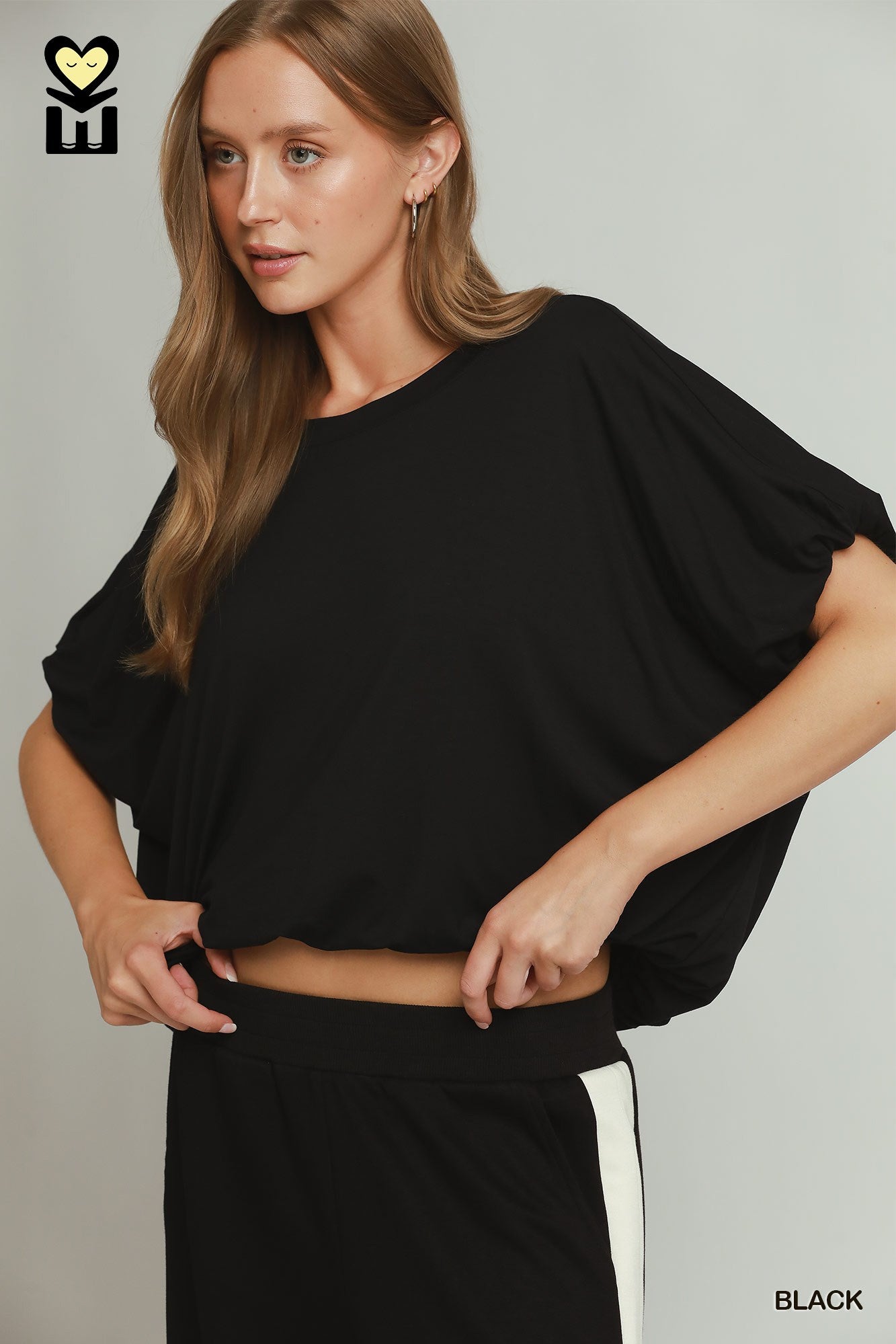 Woman wearing a black outfit with a plain background