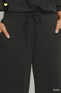 Black pants with a drawstring waist on a gray background