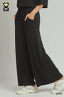 Person wearing black wide-leg pants with a neutral background