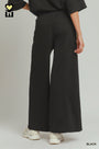 Person wearing black wide-leg pants on a plain background