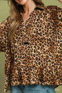Leopard print blouse worn by a person on a green background