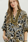 Woman wearing a patterned dress with a neutral background
