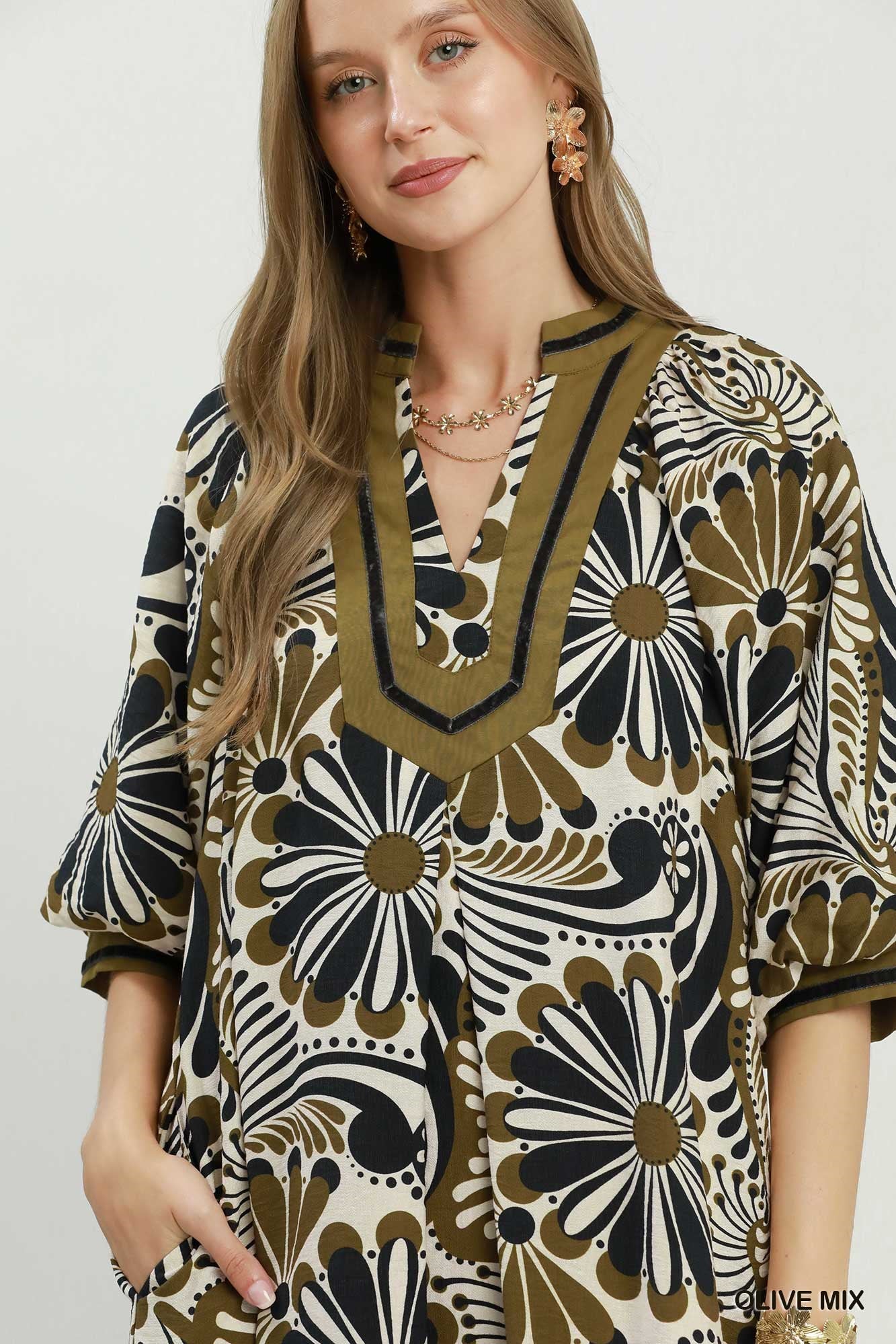 Woman wearing a patterned dress with a neutral background