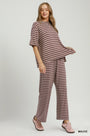 A woman modeling a two-piece loungewear set featuring a short-sleeve top and matching wide-leg pants with horizontal mauve and white stripes, set against a plain light gray studio background.