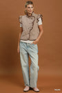 A model stands against a solid brown studio background wearing a sleeveless taupe patterned vest with ruffle trim over a white t-shirt, light-wash jeans, and pink shoes. The word 'TAUPE' is printed in white in the bottom right corner.