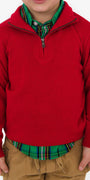 Child wearing a red sweater over a plaid shirt on a white background