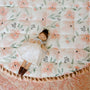 Doll lying on a floral-patterned quilt with a soft focus background