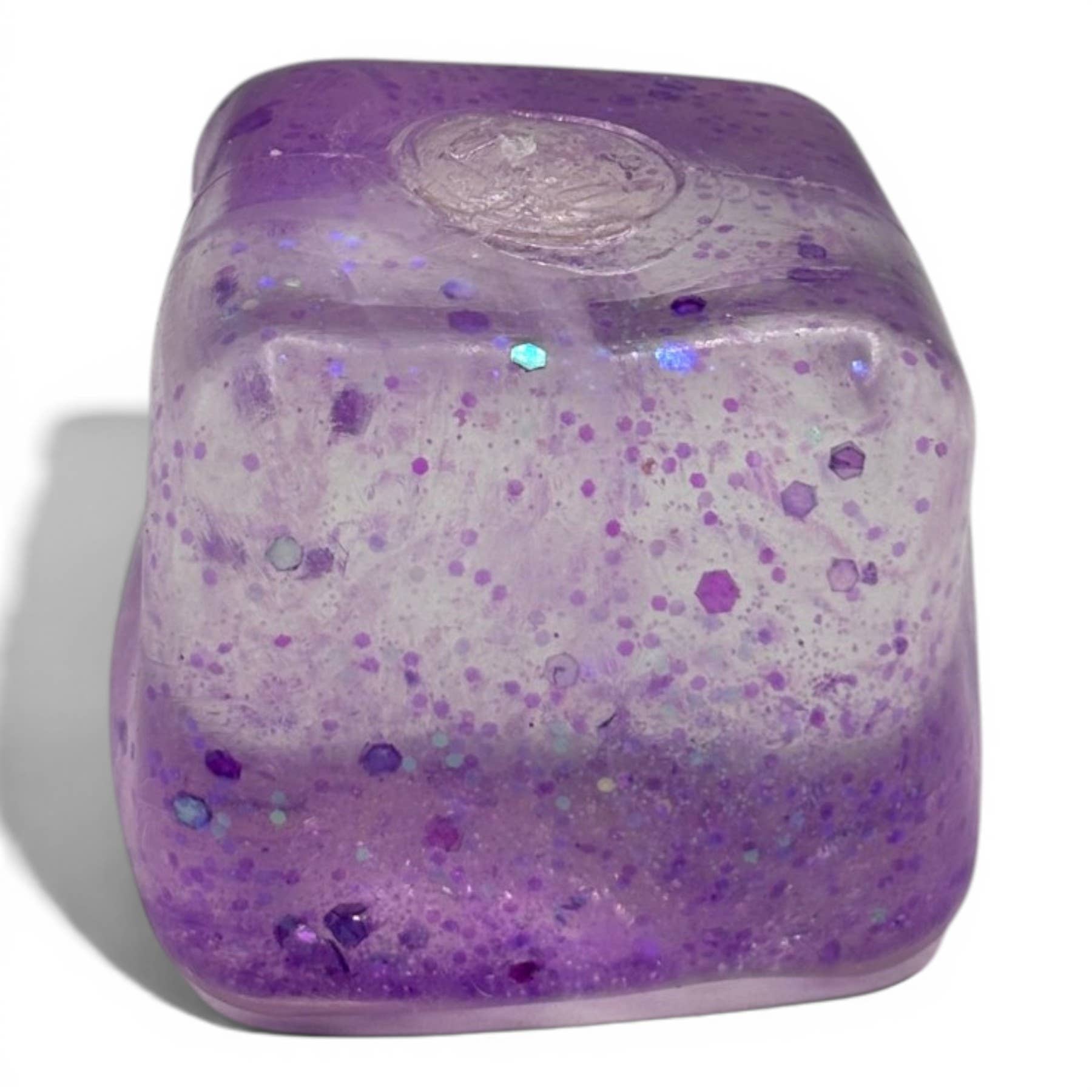 Purple glittery cube with a white center on a white background
