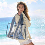Woman holding a blue and white checkered bag on a beach with ocean and sky in the background