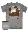A gray short-sleeve graphic t-shirt featuring a large front print of a brown dog, a football, and the text 'FIELDSTONE'. A matching gray fabric pocket patch with the Fieldstone logo is shown in the bottom-left corner against a white background.