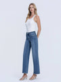 Woman wearing a white tank top and blue jeans on a white background