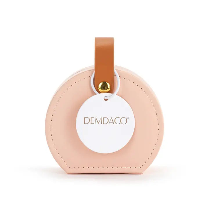 Round pink leather tag with a brown strap and gold accent on a white background