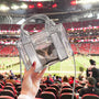Clear handbag with 'CASE-MATE' branding held in front of a sports stadium.