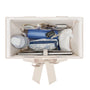 An off-white organizer box shown from above, filled with various travel accessories including a blue zippered pouch, a floral zippered pouch, a white drawstring bag, and a laptop sleeve, on a solid white background.