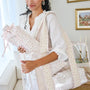 Woman holding a floral-patterned baby bunting in a home setting