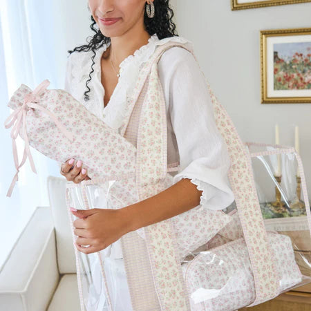 Woman holding a floral-patterned baby bunting in a home setting