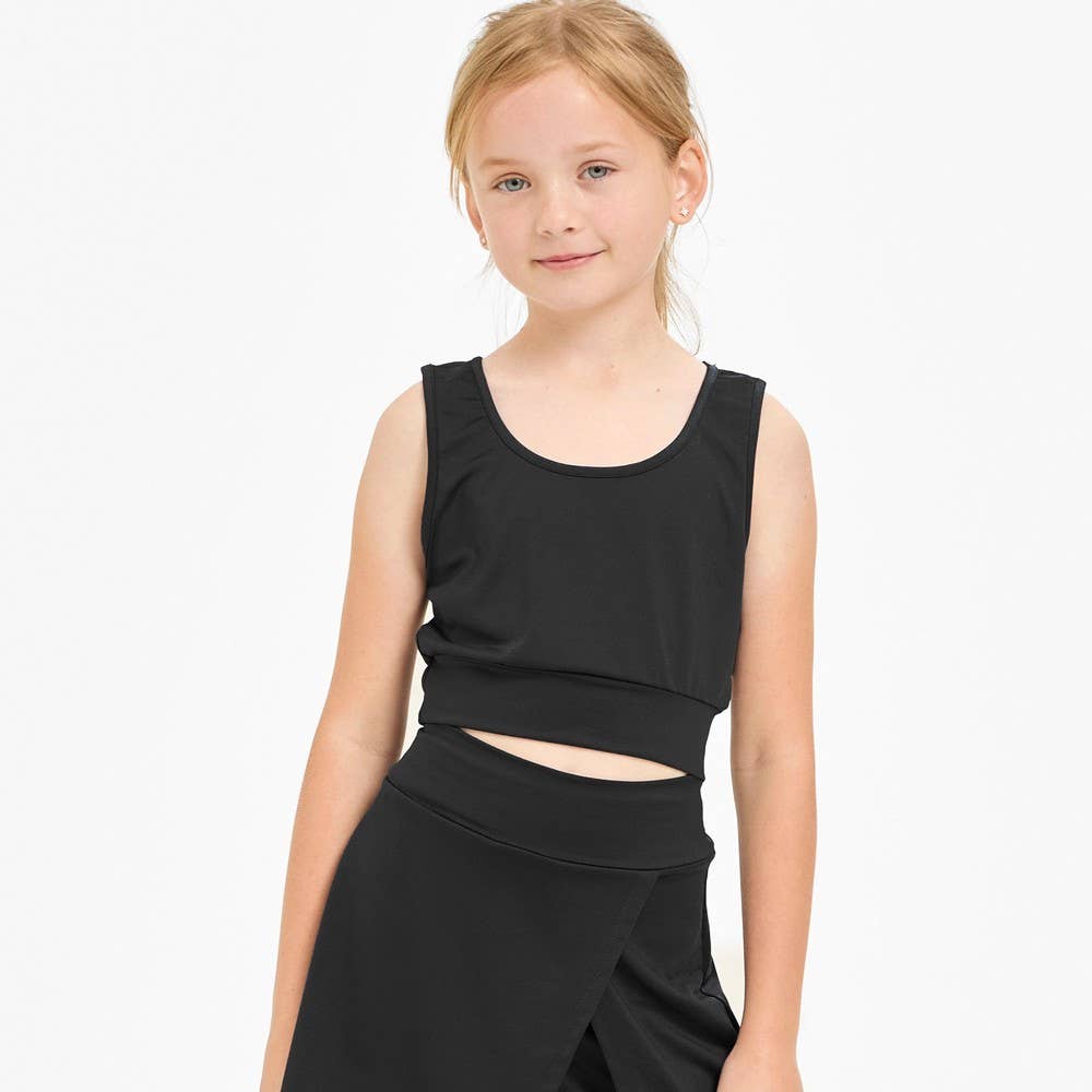 Young girl wearing a black sleeveless top and skirt set on a white background