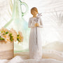 Decorative figurine of a woman holding a flower against a soft, blurred background