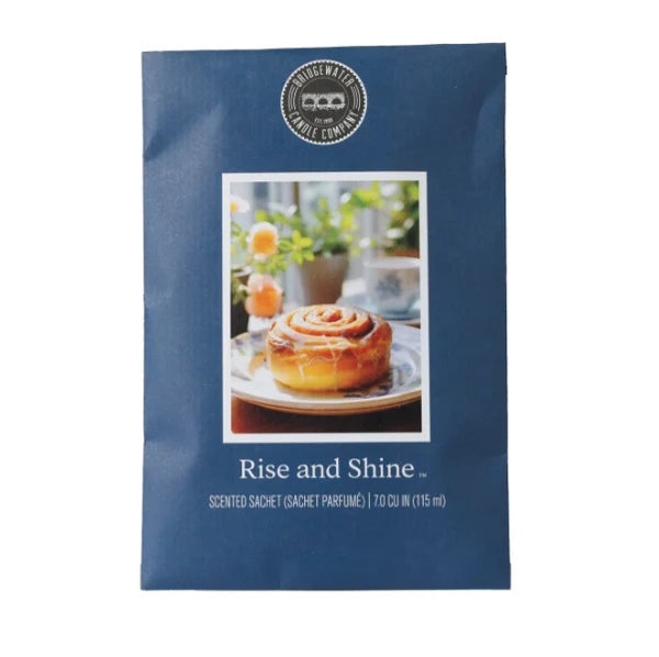 A blue scented candle packet from the brand House of Match Candle Company, featuring a photo of a cinnamon roll on the front and the scent name 'Rise and Shine'.