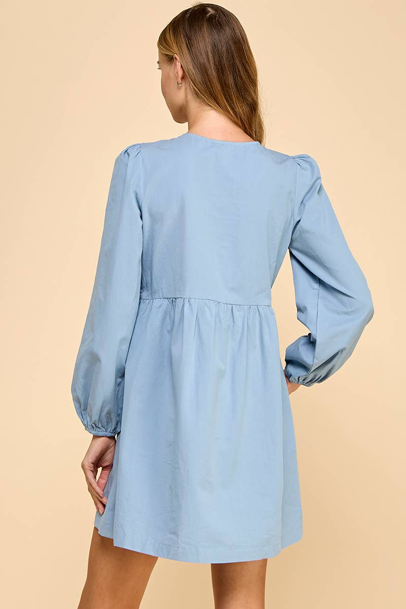 Light blue dress with long sleeves on a beige background