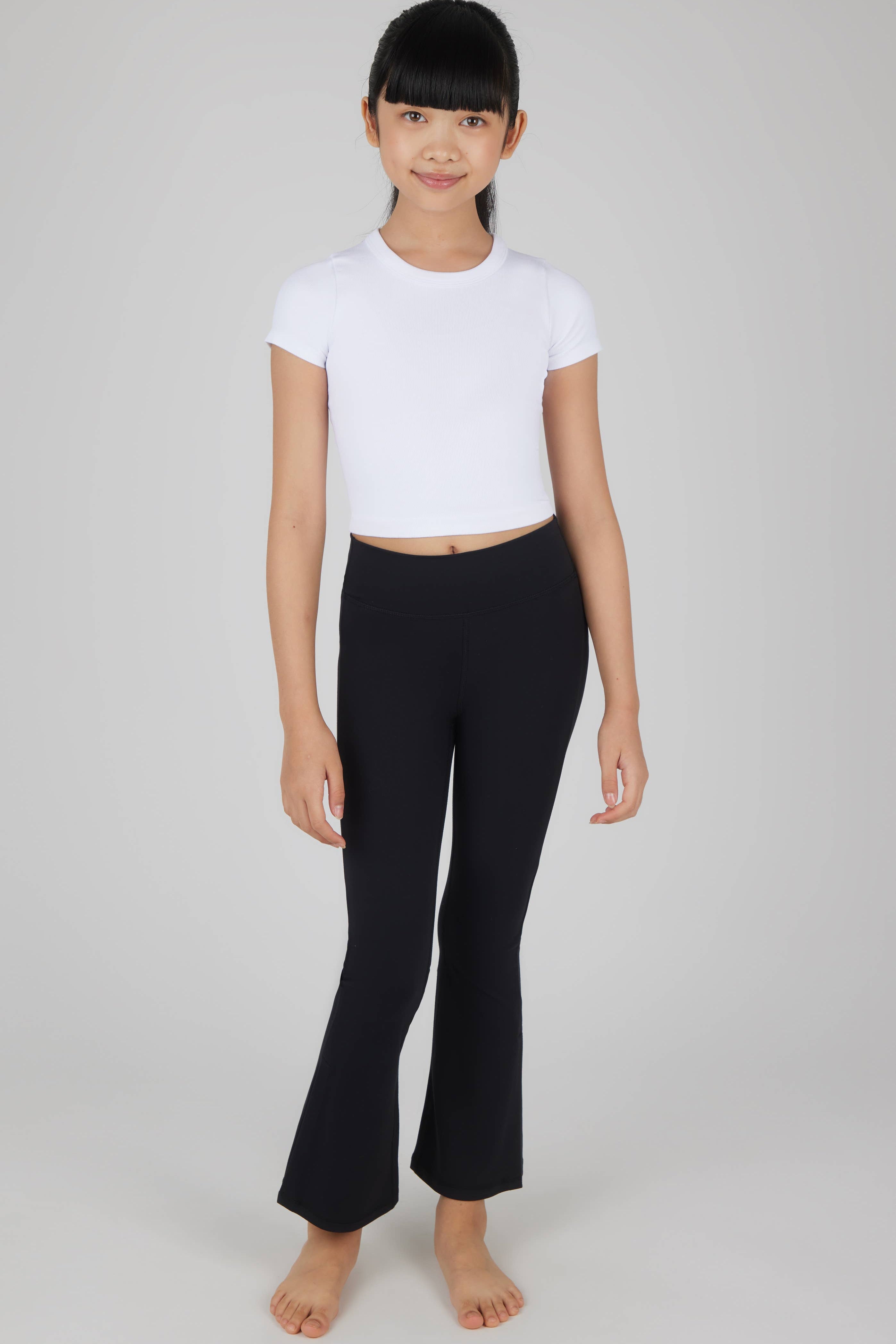 Person wearing a white t-shirt and black pants on a plain background