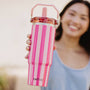 Person holding a pink striped water bottle with 'KATYDID' branding.