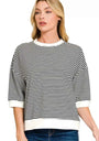 Woman wearing a black and white striped sweater with a plain background