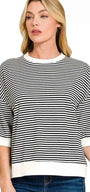 Woman wearing a black and white striped sweater with a plain background