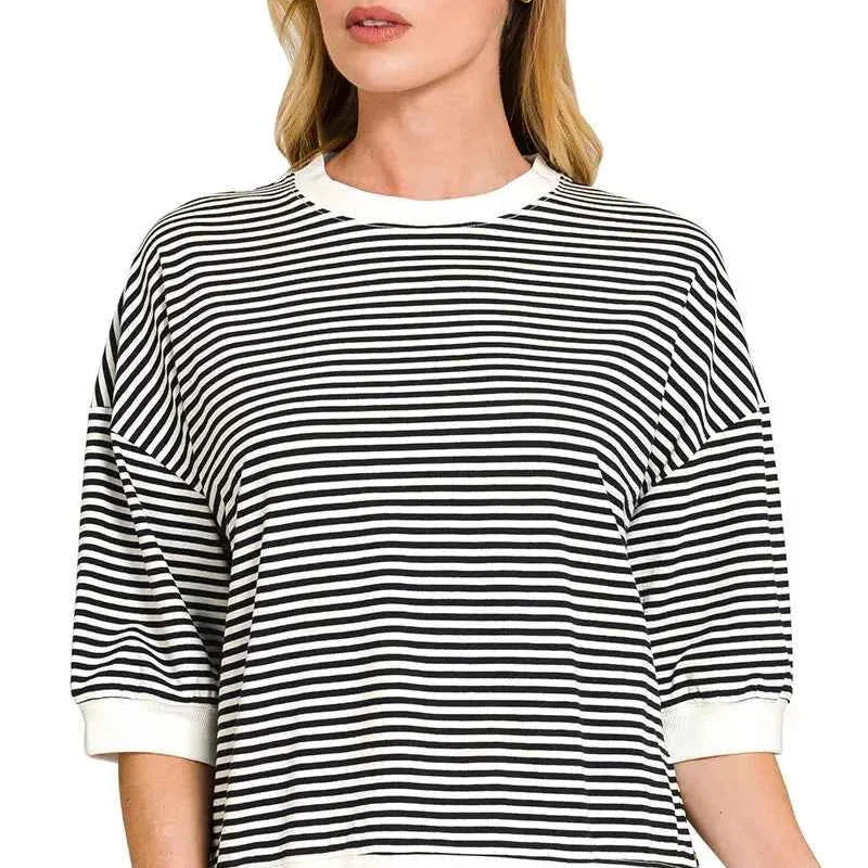 Woman wearing a black and white striped sweater with a plain background