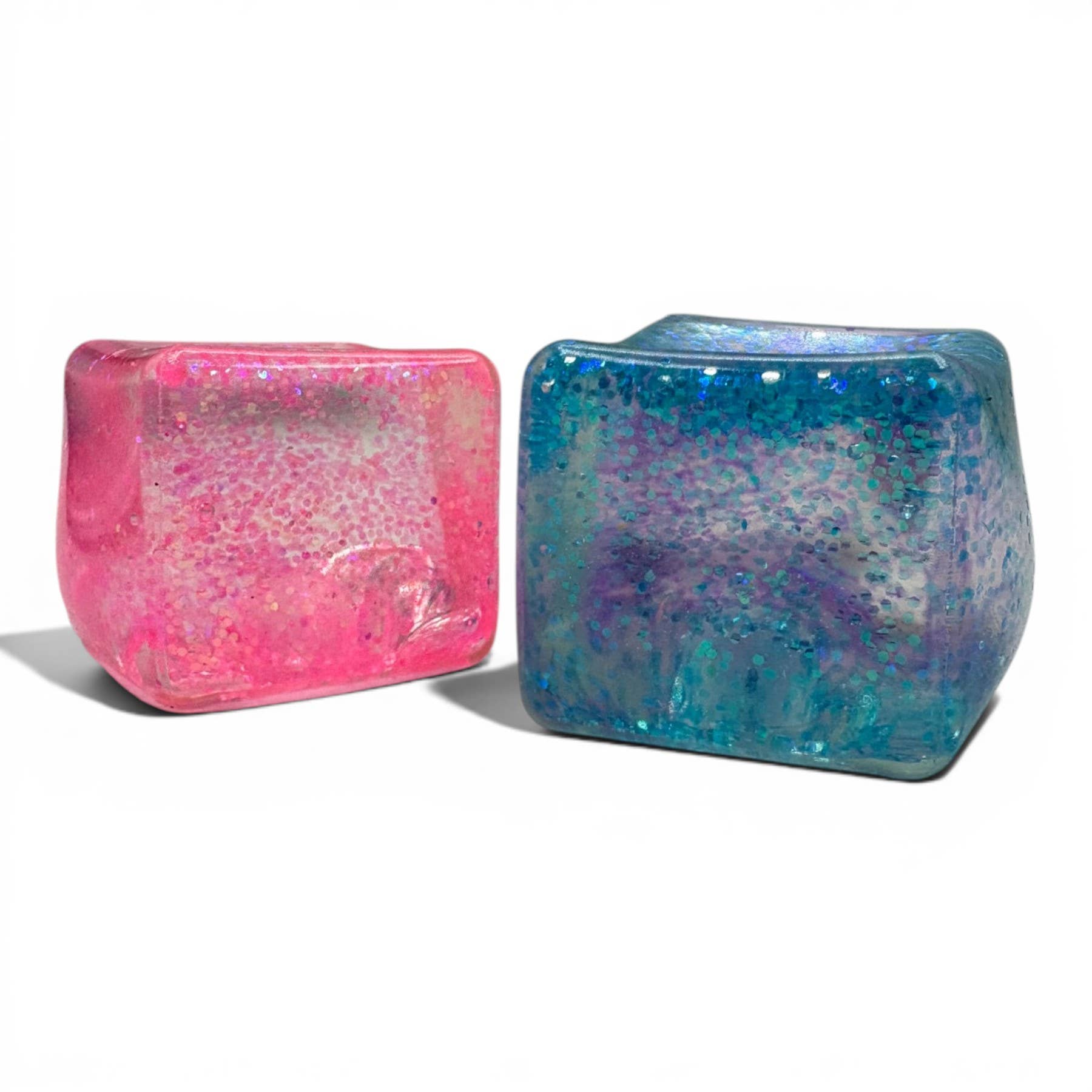 Two colorful glittery cubes, one pink and one blue, on a white background.