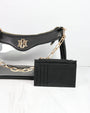 Black handbag with gold chain and cardholder on a white background