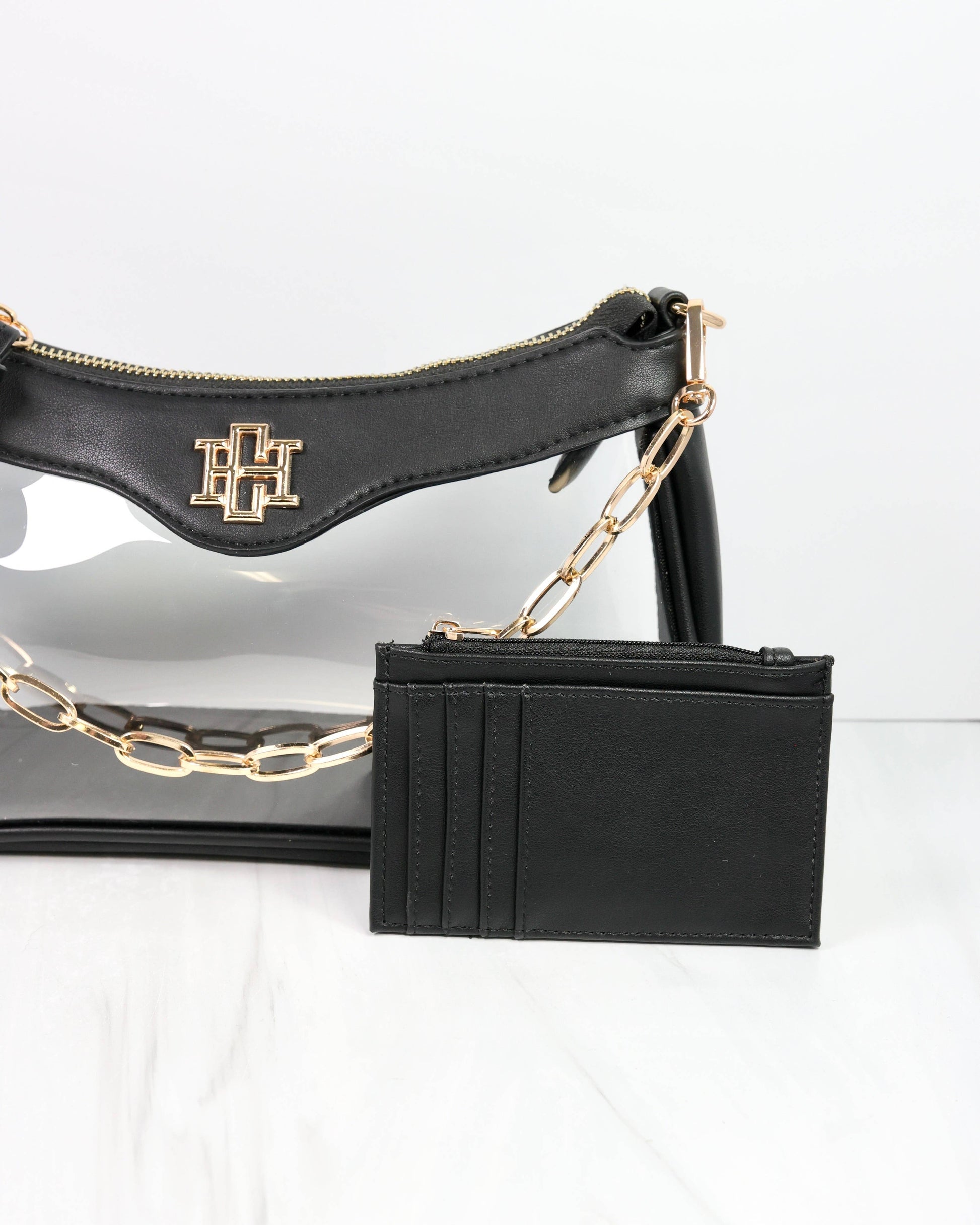 Black handbag with gold chain and cardholder on a white background