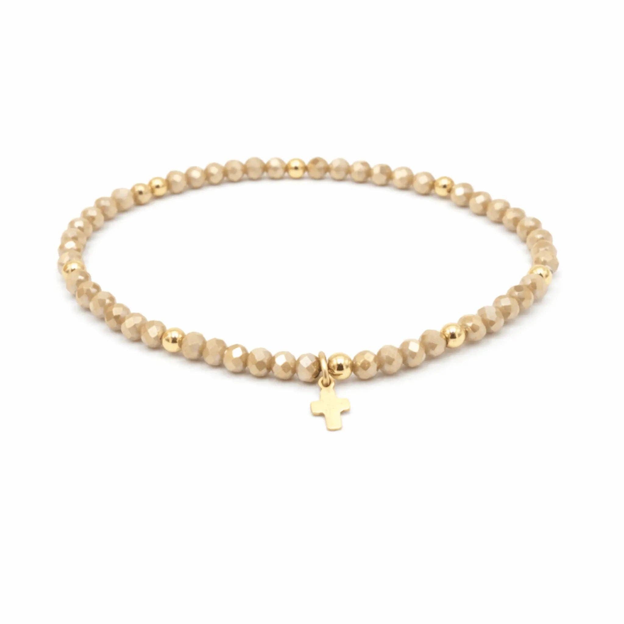 Beaded bracelet with a gold cross charm on a white background