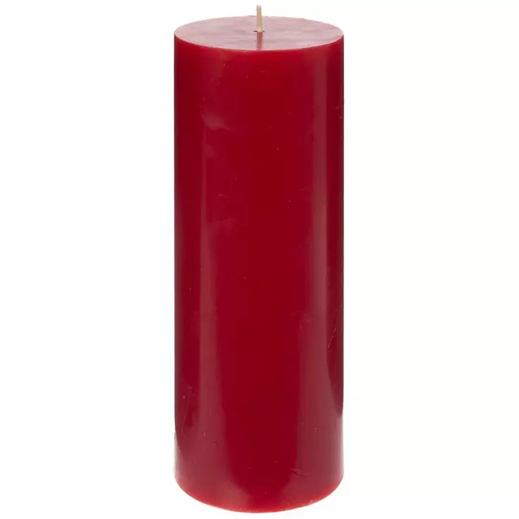 A single tall, cylindrical red pillar candle with a visible wick, centered against a plain white background.