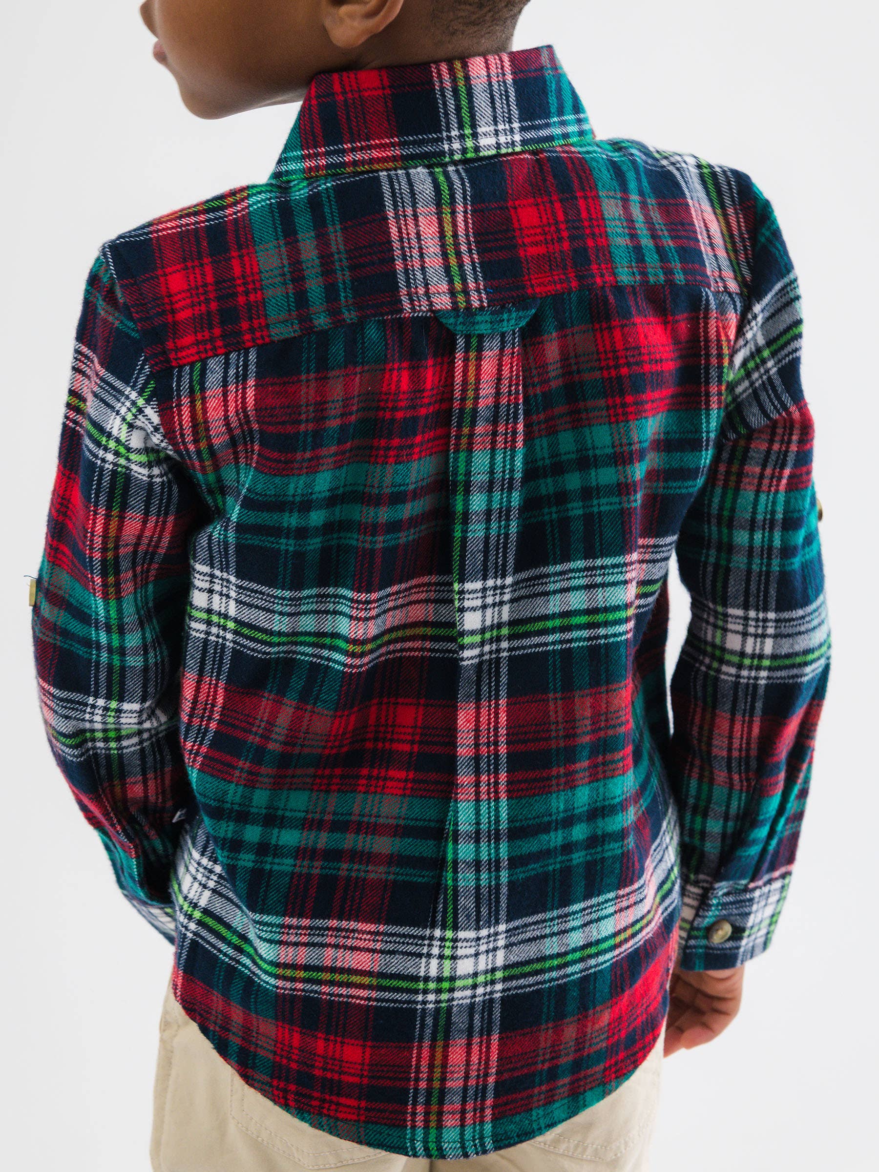 Person wearing a red, green, and white plaid shirt on a white background