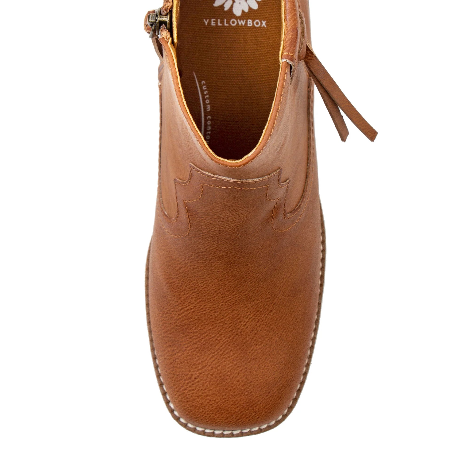 A top-down view of a tan leather ankle boot with decorative stitching and a pull strap, shown on a plain white background. The brand name 'YELLOWBOX' is visible inside the collar.