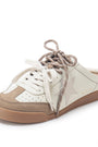 A low-top slip-on sneaker in off-white and beige suede with a brown gum sole, featuring a star-shaped side detail and matching brown laces, shown on a white background.
