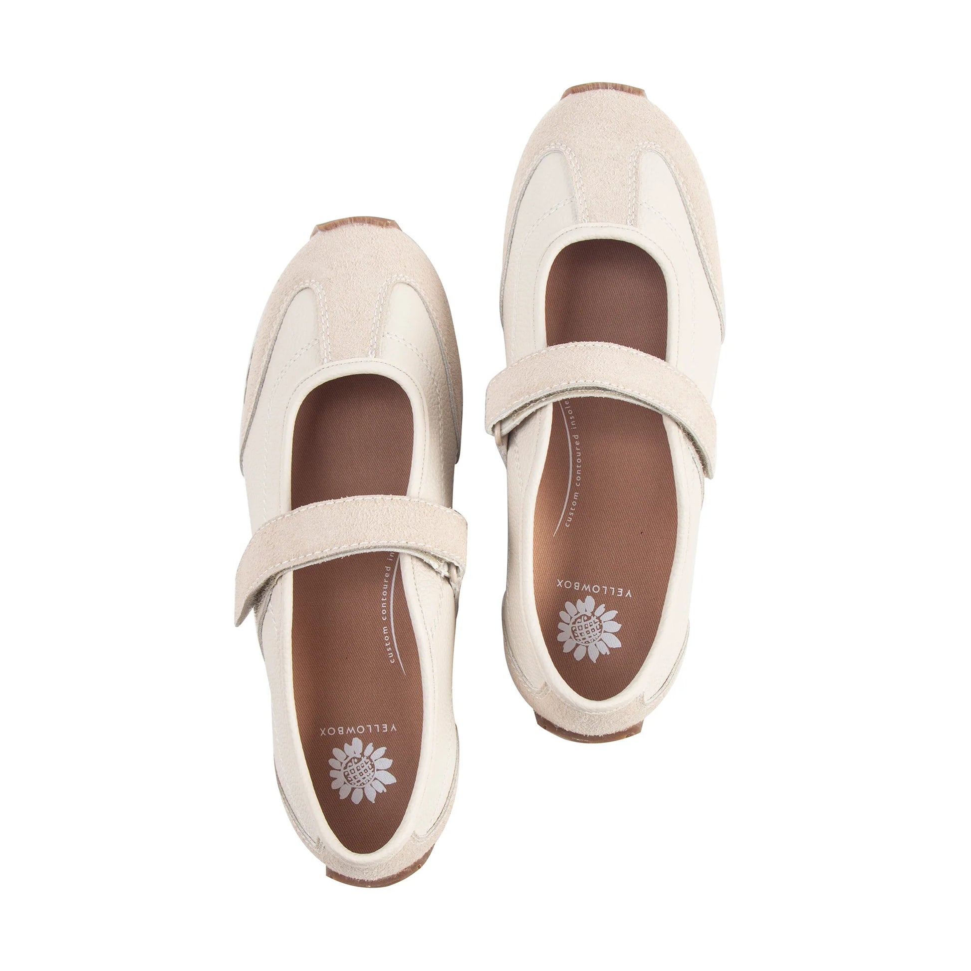 Pair of beige shoes with brown soles on a white background