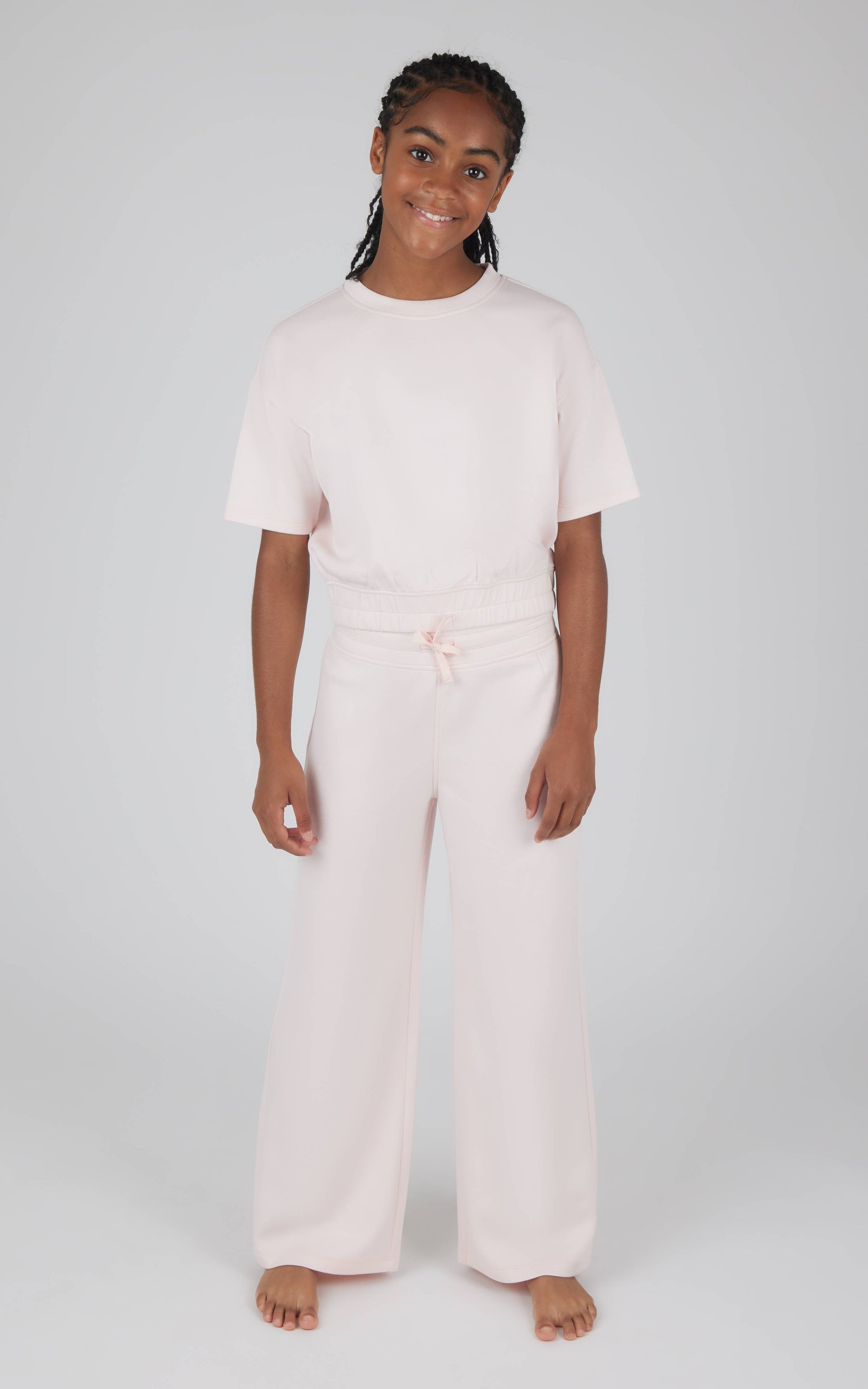 Person wearing a white two-piece outfit on a plain background