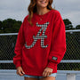 Crimson crewneck sweatshirt with houndstooth letter A graphic and Lulu Mac cuff patch