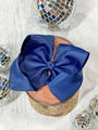 Blue bow on a wooden block with disco balls in the background