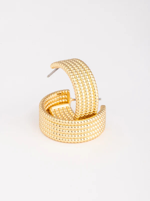 Gold hoop earrings on a light gray background